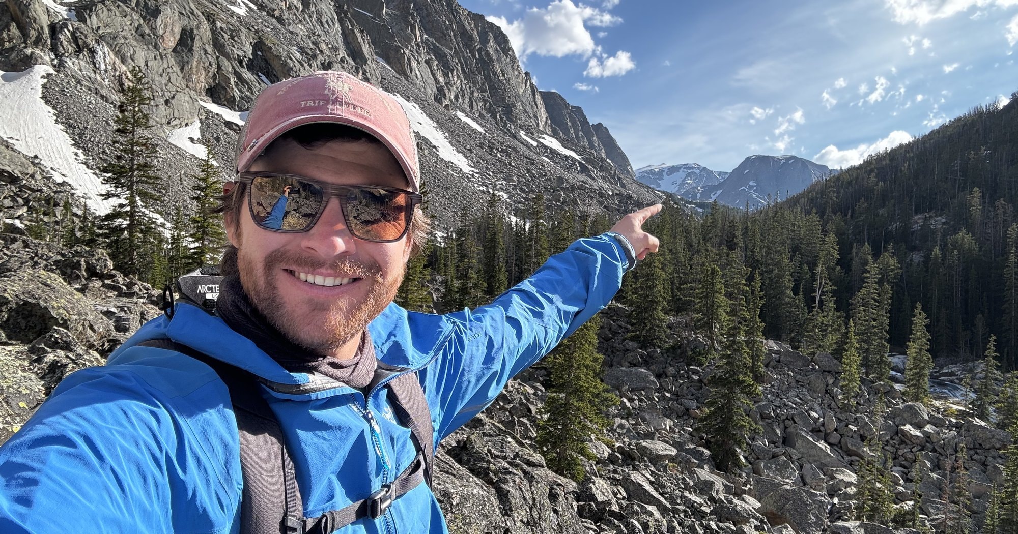 George Bull pointing toward a distant peak on a backcountry expedition.